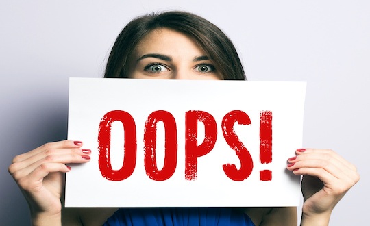 Young woman with "oops" sign and expression