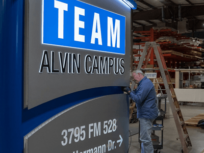National Signs employee works on sign fabrication for the TEAM Alvin Campus sign