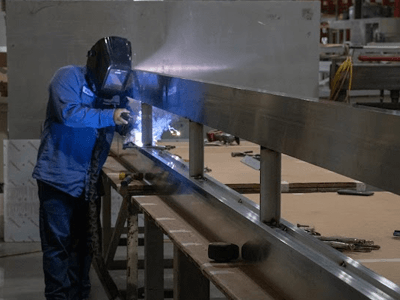 Welder joins components of a sign in the National Signs warehouse