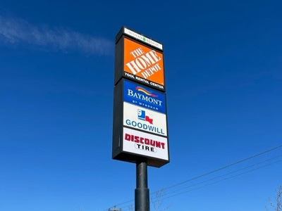 Tall pylon sign with various business logos on it.