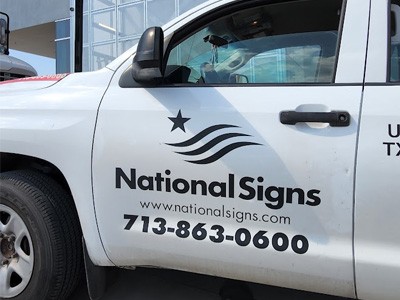National Signs work truck door with the National Signs Logo and contact info printed on it