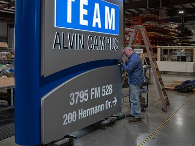 National Signs employee puts finishing touches on a monument sign.